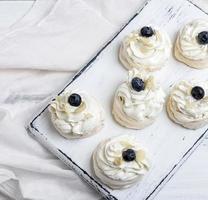 baked round meringues with whipped cream photo