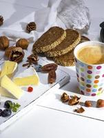 mug with black coffee and pieces of camembert cheese photo