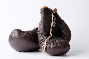 Par de guantes de boxeo de cuero marrón vintage sobre un fondo blanco. foto