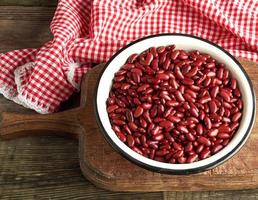 raw oval red beans in a plate on a wooden table photo