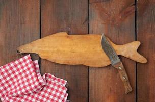 wooden cutting board in the shape of a fish and a sharp knife photo