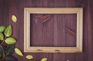 Empty wooden frame on brown wooden surface photo