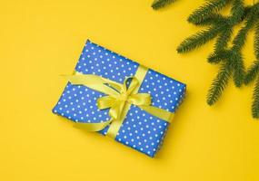 blue gift box tied with ribbon on a gray background, top view. photo