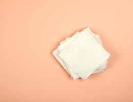 pila de servilletas de papel blanco sobre un fondo beige, vista superior foto