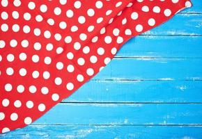 red textile towel with white circles on a blue wooden background photo