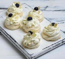 baked round meringues with whipped cream photo