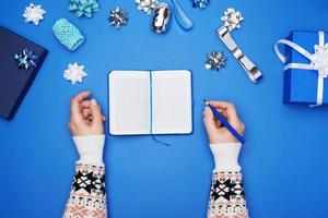 open notebook with empty white sheets and two female hands photo