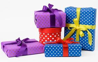 stack of boxes wrapped in paper and tied with a silk ribbon on a white background, celebration photo