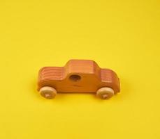 coche infantil de madera sobre un fondo amarillo foto