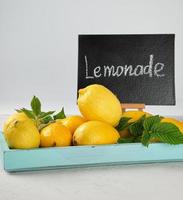 fresh ripe whole yellow lemons and black frame with an inscription lemonade photo