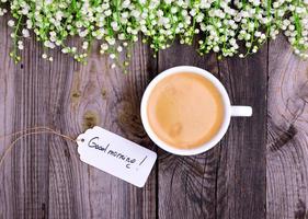 Cup of coffee with foam on a gray wooden background photo