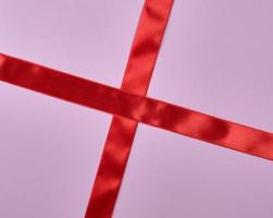 red satin ribbon cross to cross on purple background photo