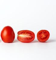 ripe red whole tomatoes and pieces on a white background, autumn harvest photo