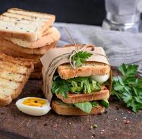 sandwich of French toast and lettuce leaves and boiled egg photo