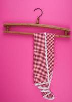 red checkered kitchen towel hanging on a vintage wooden hanger photo