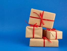 stack of boxes wrapped in brown paper and tied with a red bow photo
