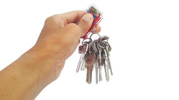 Hand holding bunch of keys on key ring on white background photo