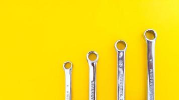 Various sizes of wrench or spanner isolated on yellow background. Mechanical Tool. photo