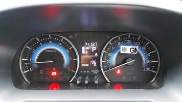 Close-up view of a car panel with a speedometer with brake and seat belt light indicators on photo