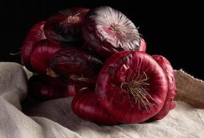 round red onion in husk on a gray linen napkin photo