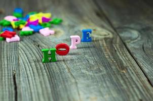 Words of hope from small wooden letters on a gray surface photo