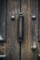iron door hinge on old brown wooden doors photo