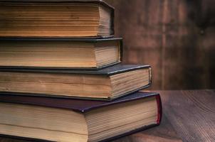 stack of old books on a brown wooden background photo