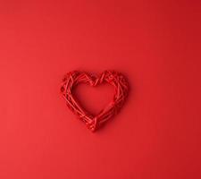 red wicker decorative heart on a red paper background photo