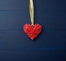 red wicker decorative heart hanging on golden silk ribbon photo