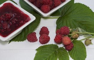 Jam with raspberries and fresh raspberries photo