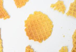 baked round belgian waffles on white background, broken pieces and crumbs photo