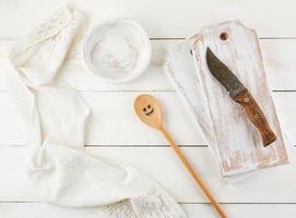 cuchara de madera, plato, cuchillo y tabla de cortar foto