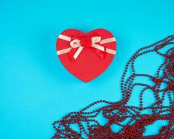 caja de regalo roja en forma de corazón con lazo foto