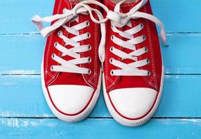 a pair of red textile sneakers with white laces photo