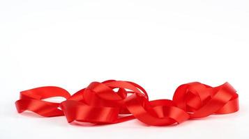 curled red satin ribbon on white background, festive backdrop photo