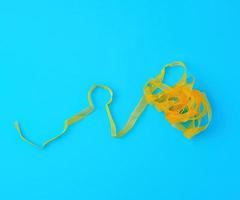 curled yellow satin ribbon on blue background photo