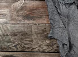 black textile kitchen towel on a wooden background from old gray boards photo