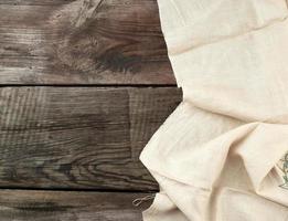 white kitchen textile towel folded on a gray wooden table from old boards, top view, empty space. Rustic texture. Retro background photo