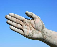 Man's open palm smeared with mud photo