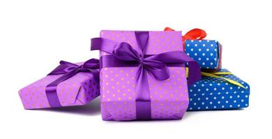 a stack of boxes wrapped in paper and tied with a silk ribbon on a white background, celebration photo