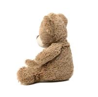 cute brown teddy bear sitting sideways on white isolated background photo