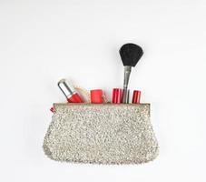 open silver clutch and cosmetics fell out of the middle photo