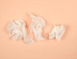 servilletas de papel blanco arrugadas sobre un fondo beige foto
