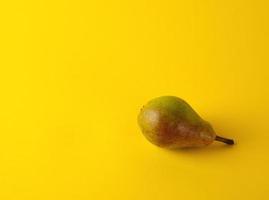 one ripe green pear on a yellow background photo