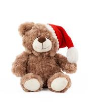 pequeño y lindo oso de peluche marrón con un sombrero rojo de navidad se sienta foto