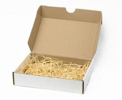 rectangular open corrugated paper box with sawdust inside. Packaging, containers for transportation photo