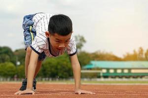 los niños asiáticos comenzaron a correr en la pista por el concepto de juego al aire libre, actividades al aire libre, actividades de ocio, ejercicio. enfoque suave y selectivo. foto