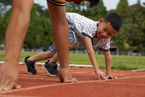 padre e hijo comenzaron a correr juntos en la caminadora. en el concepto de juegos al aire libre, actividades familiares, actividades al aire libre. enfoque suave y selectivo. foto