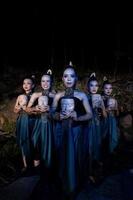 A Group of Balinese woman line up with the wooden mask in their hands while wearing a traditional dance costumes photo