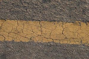 Yellow line background with cracks on the old road photo